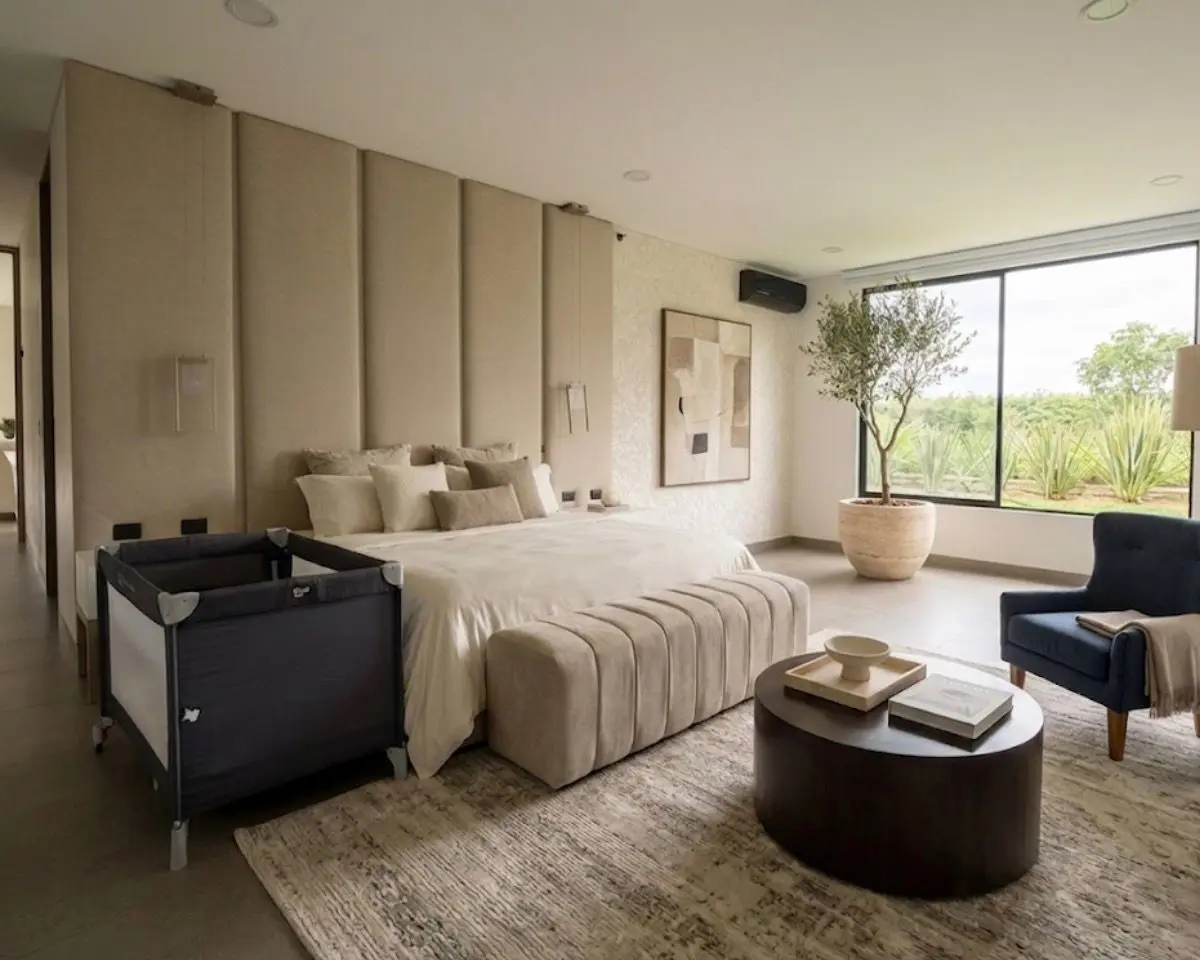 Suite principal con cabecero tapizado y ventana al jardín