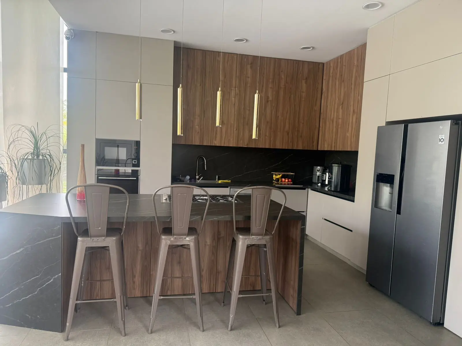 Cocina con gabinetes en madera y lámparas colgantes
